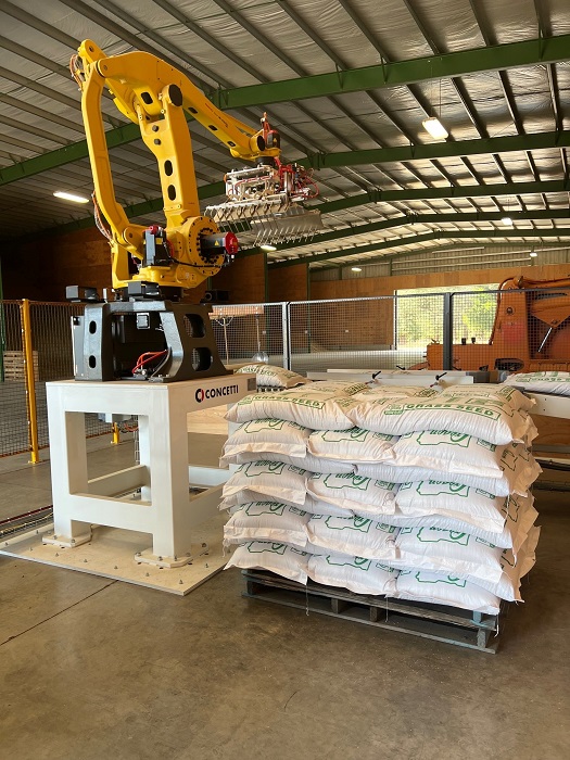 Image of a Bratney robot palletizer stacking grass seed bags