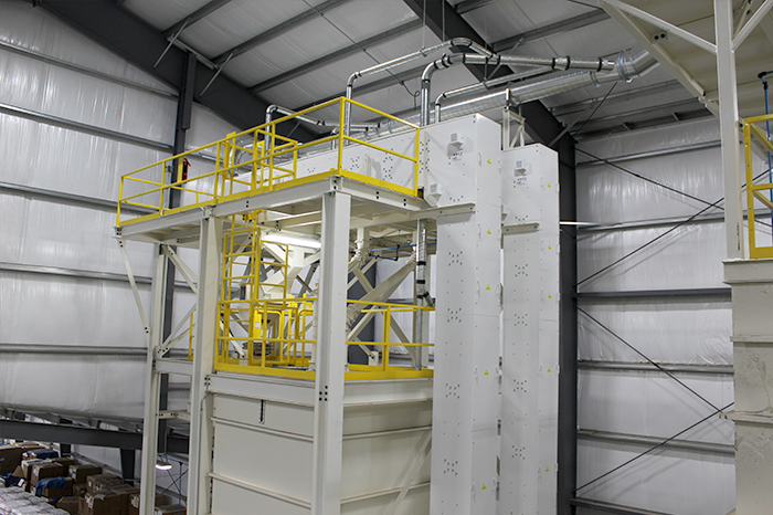 Continuous cup elevators conveying finished popcorn to the bulk bagging storage bin.